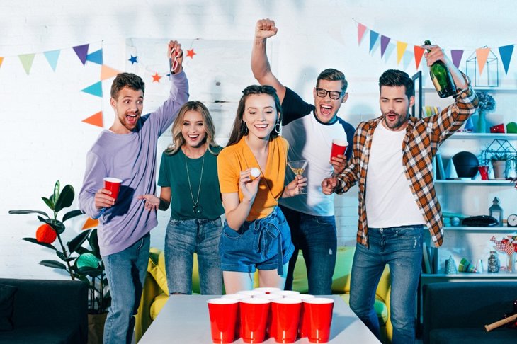 Unge der spiller beer pong til en fest