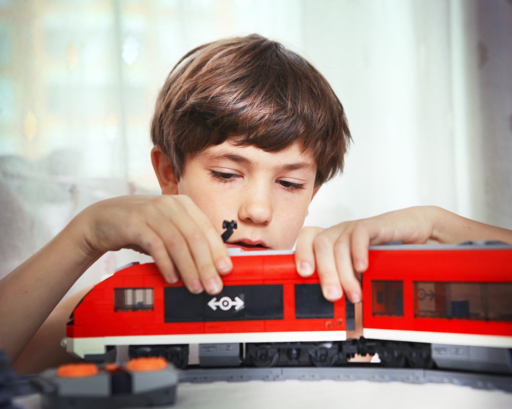 Dreng der leger med tog